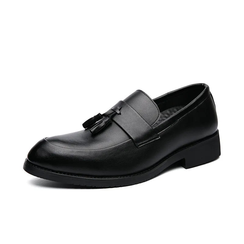 Men's black tassel loafers with a slip-on design and rubber sole on a plain background.