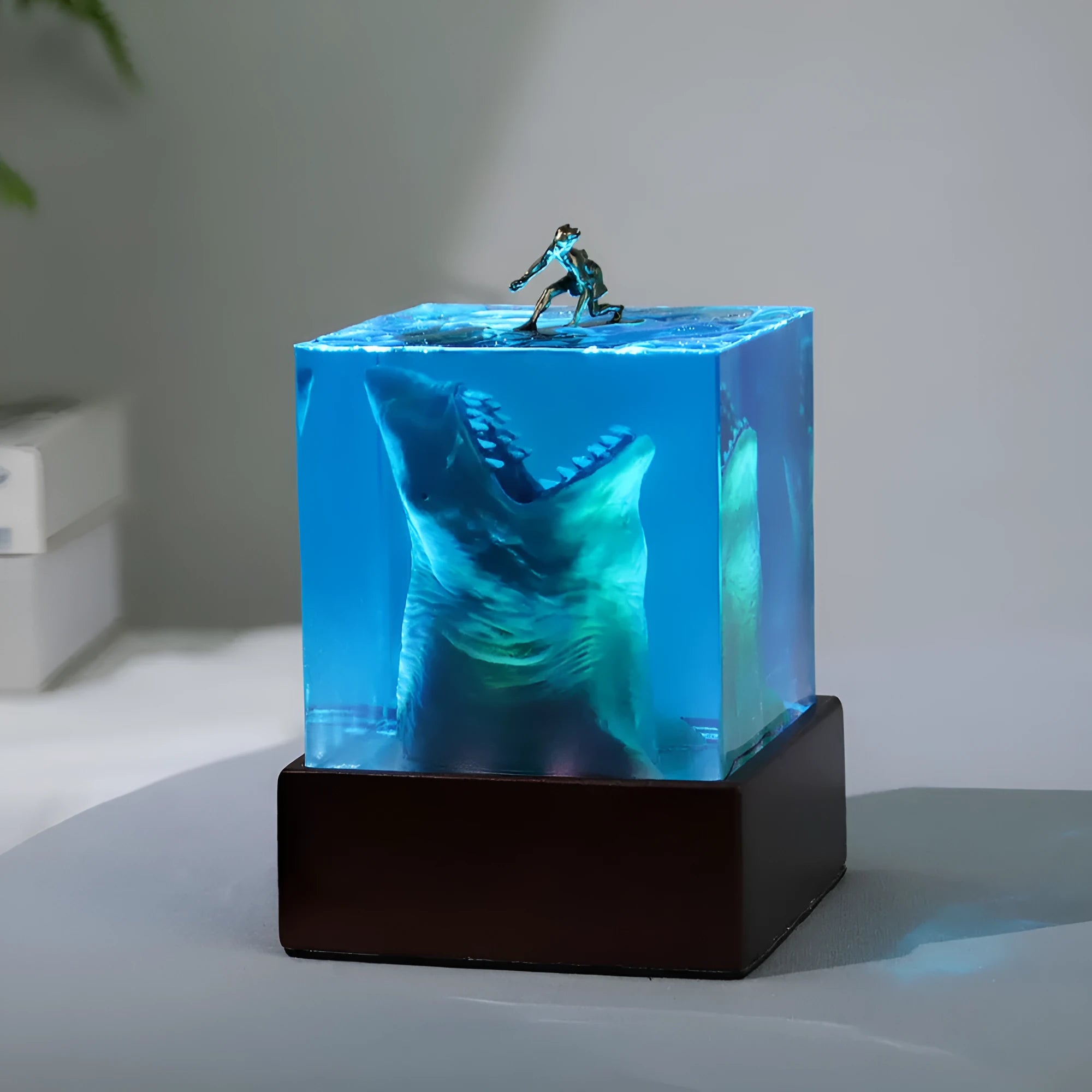 Epoxy resin shark surfer night light ornament on a desk with glowing micro landscape.