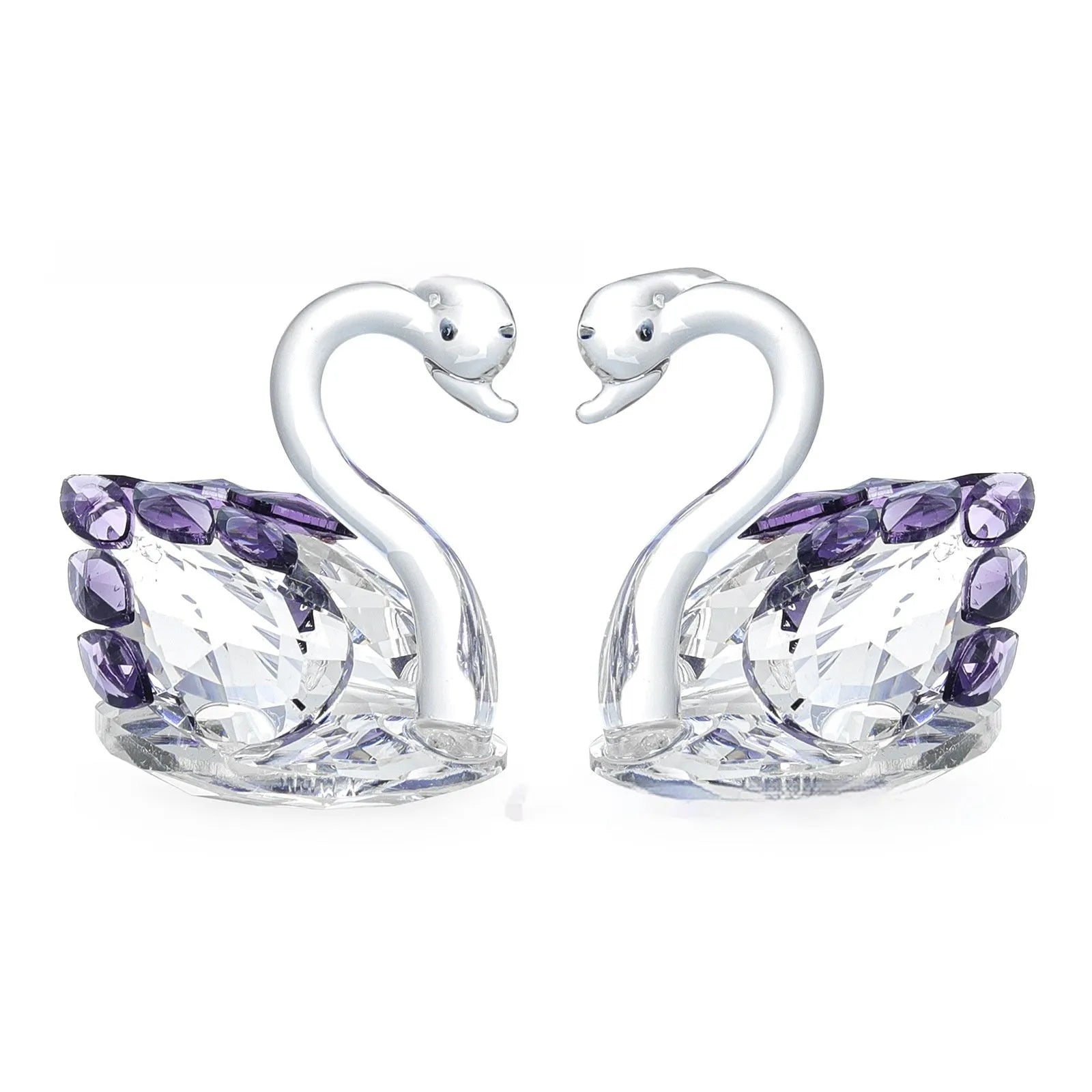 White crystal swan decoration on a desktop in solid head and empty tube styles.