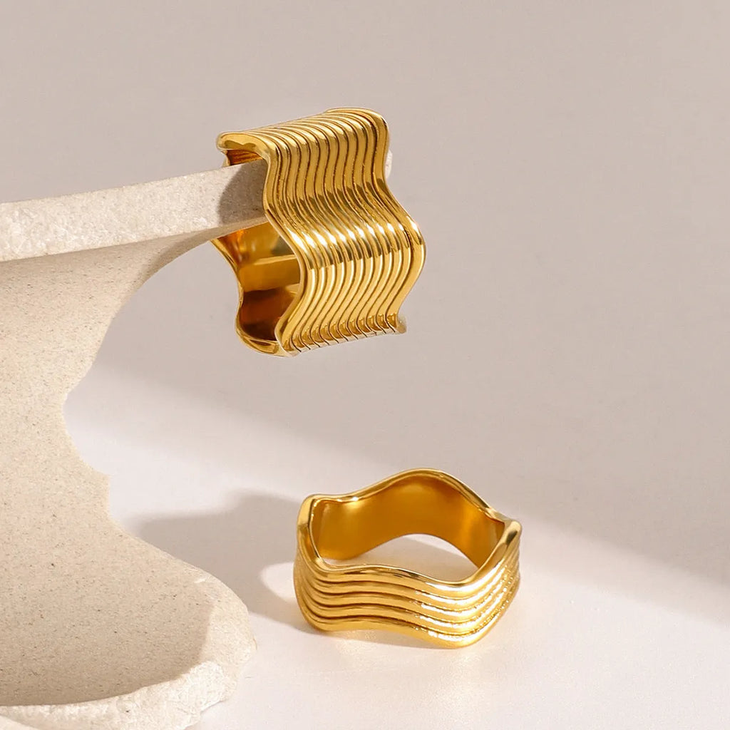Geometric wide band stainless steel wave ring for women with electroplated finish.