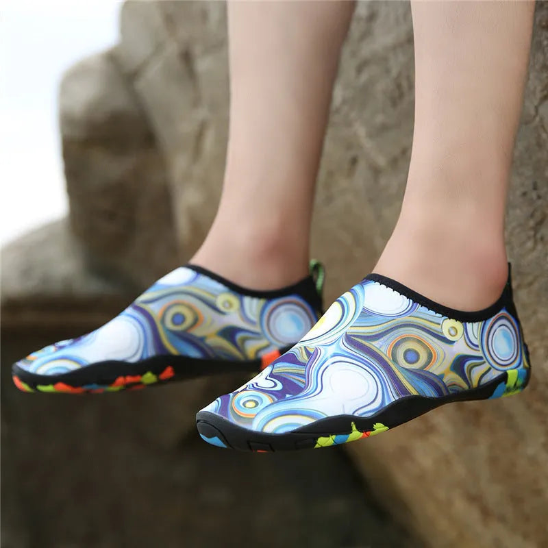 A pair of beach wading shoes for swimming, shown in camouflage colour with Lycra upper and EVA sole.