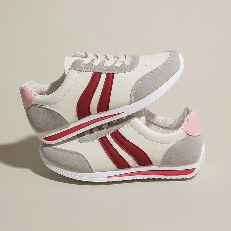 Red low-top lace-up running sneaker with round toe and rubber sole.