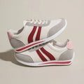 Red low-top lace-up running sneaker with round toe and rubber sole.