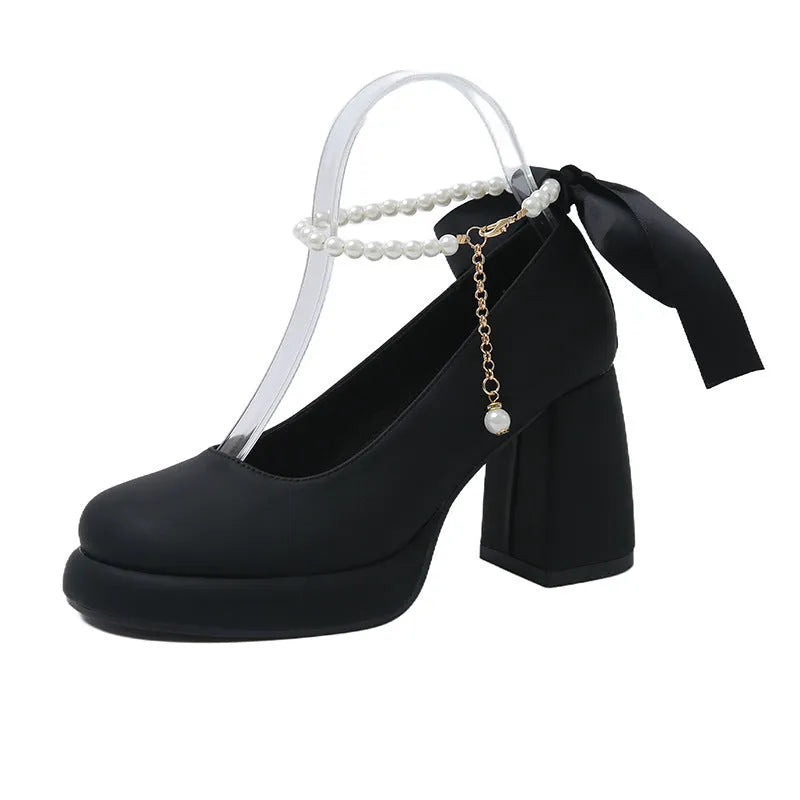 Women's beige Mary Jane shoes with a chunky block heel and an ankle-strap buckle on a round toe.