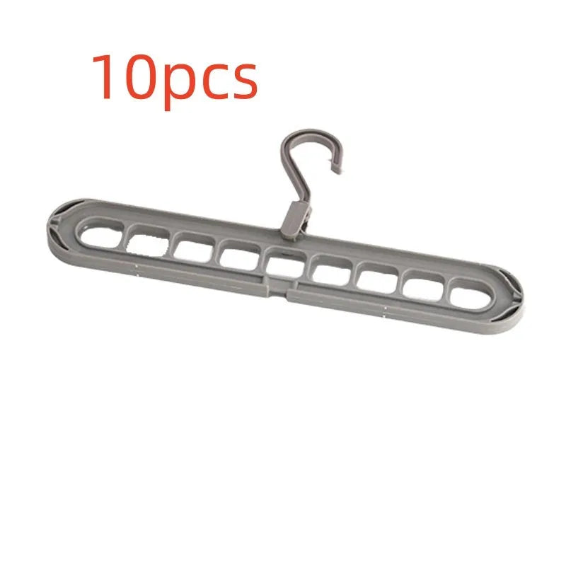 Green plastic folding clothes hanger with nine holes for organising trousers on a rack.