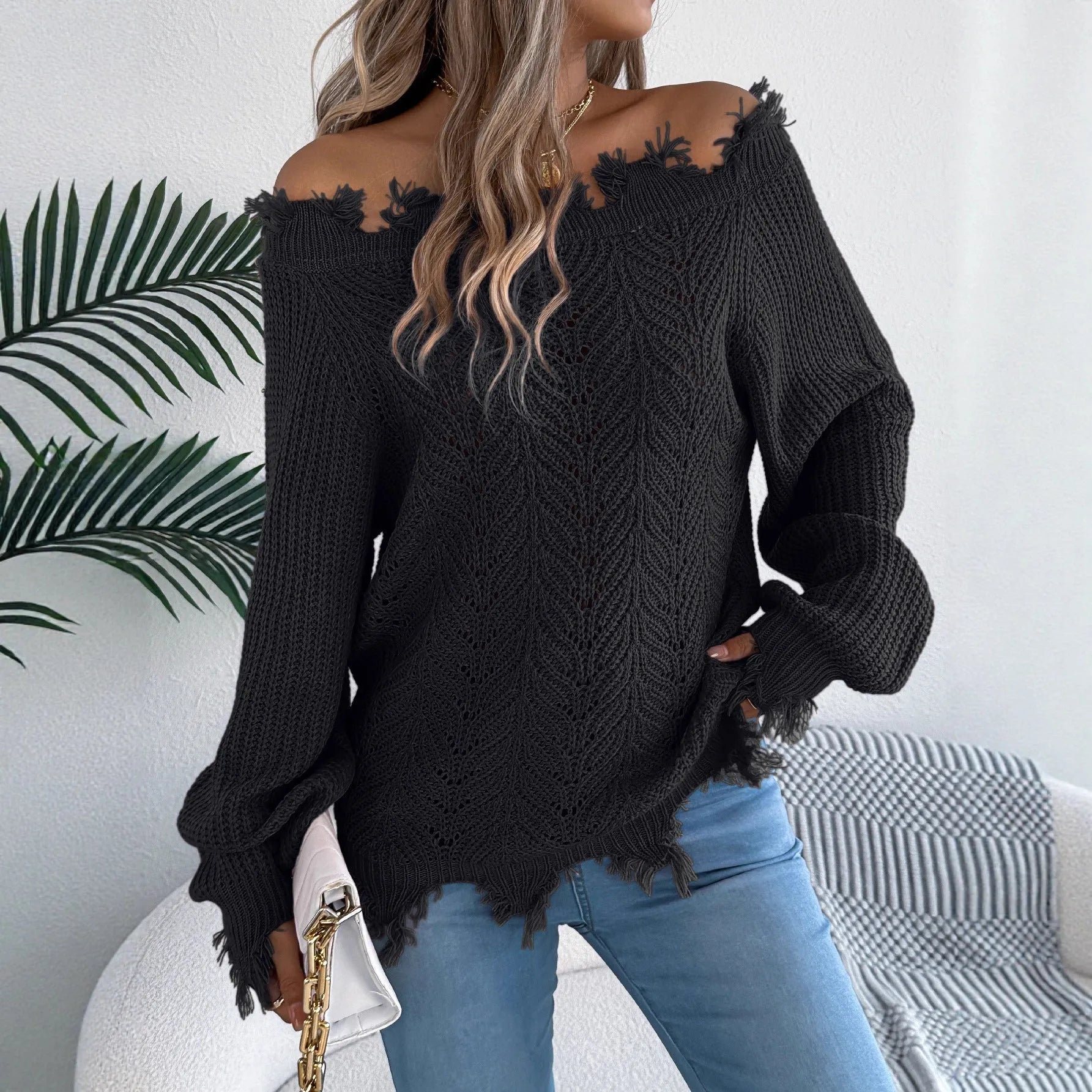 White women's hollow-out knit sweater with an off-the-shoulder neckline and long sleeves.