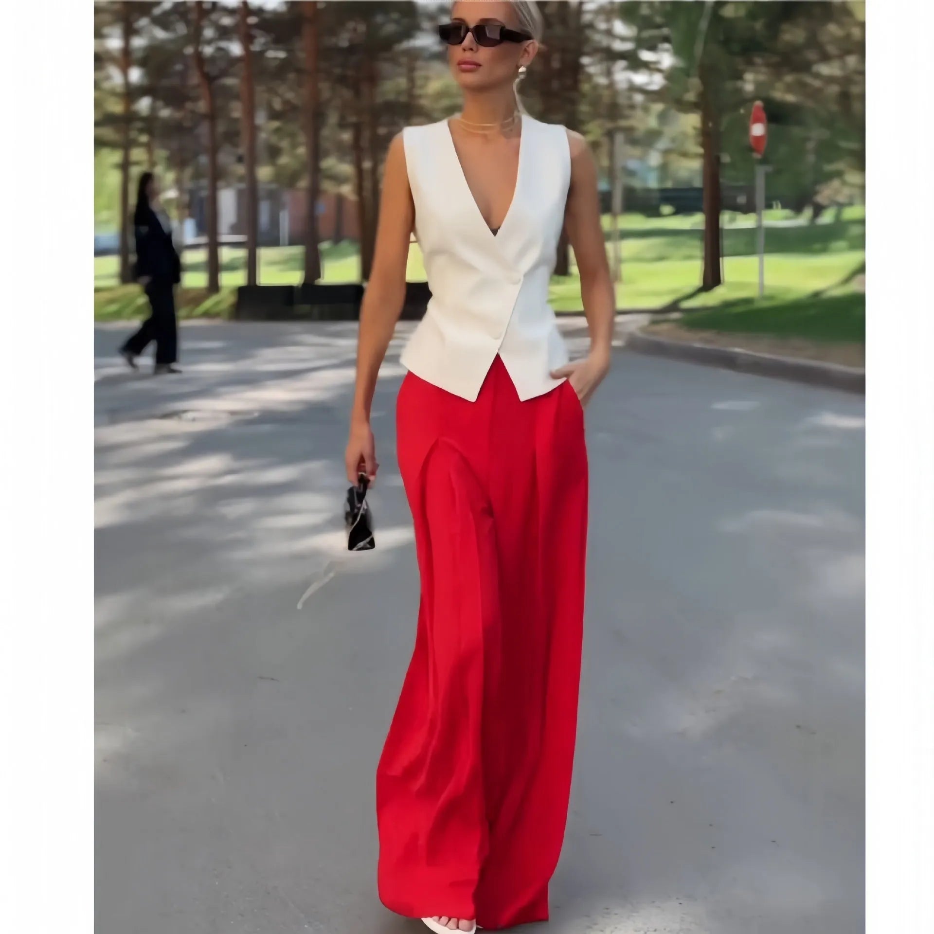 Women's beige two-piece set with deep V-neck sleeveless top and high-waisted wide leg trousers.