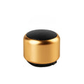 Small portable Bluetooth speaker in black, blue, gold, or pink colour on a table.