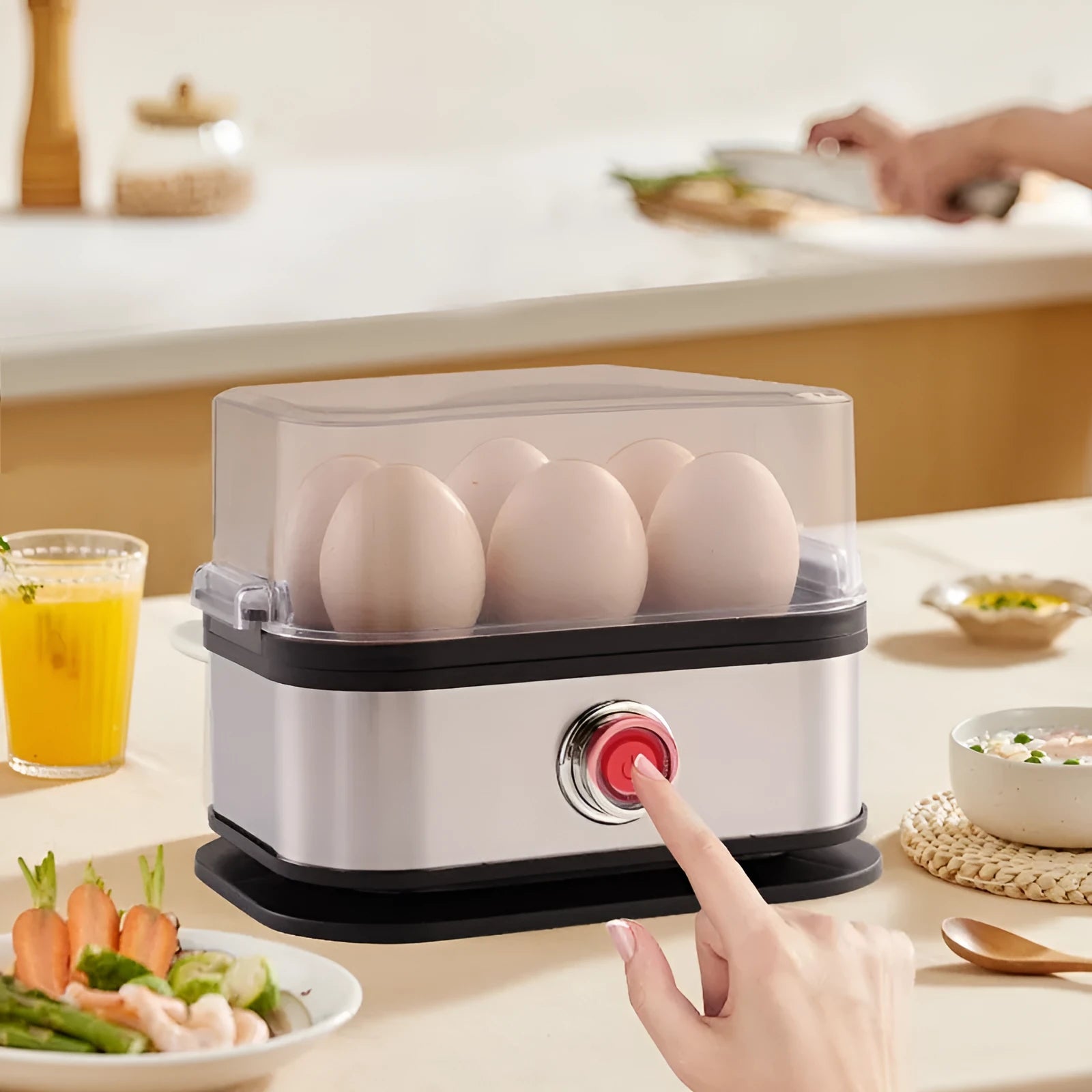 Black portable stainless steel egg boiler with carrying belt on a table.