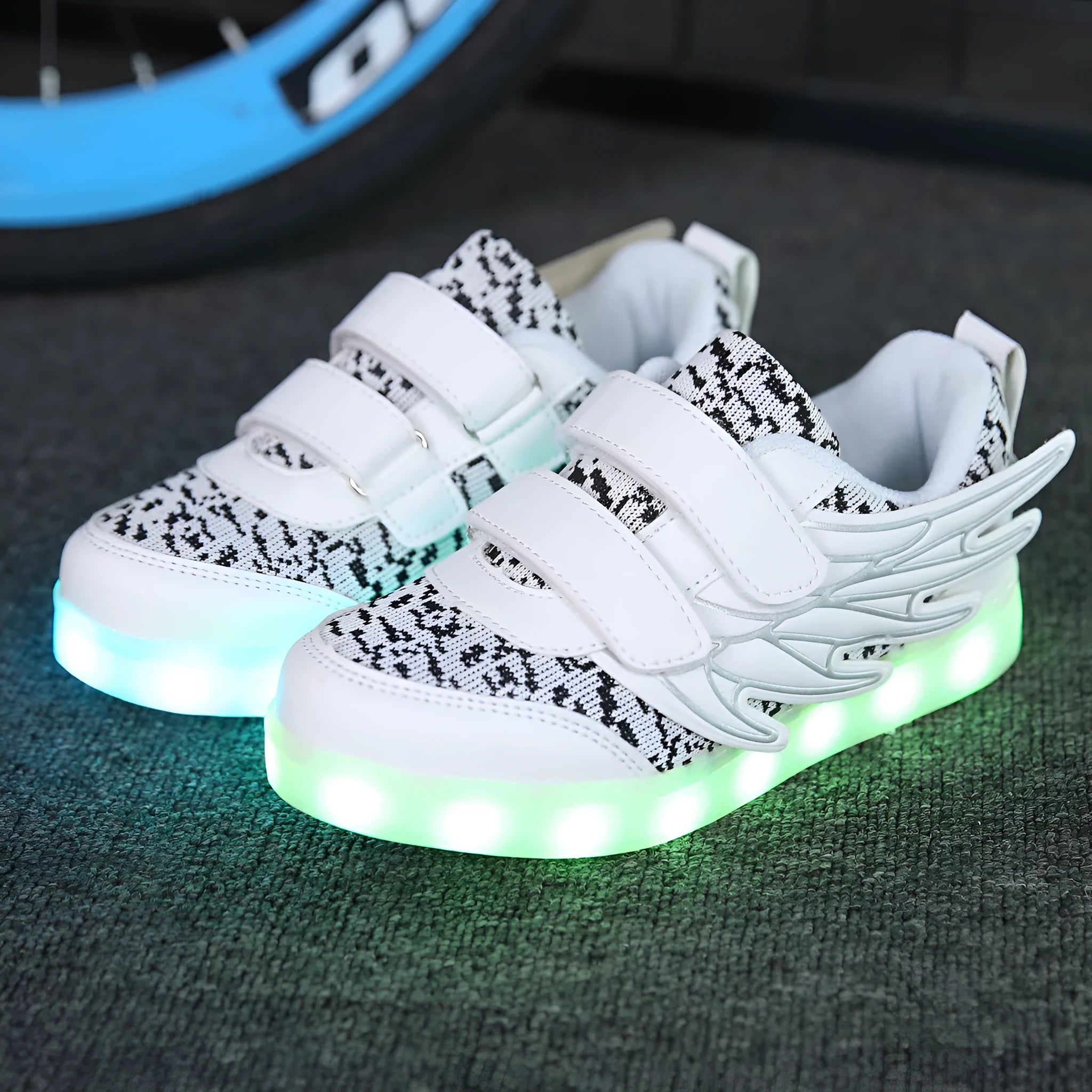 Plum red children's sneakers with LED lights glowing on the soles, showing USB charging port.
