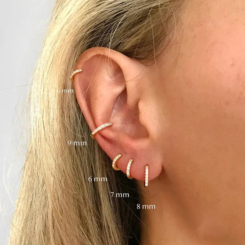 Perforated geometric circle stud earrings in gold, rose gold, and silver colours on a white background.