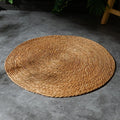 Natural papyrus round rattan cat scratching pad in winter brown colour on floor