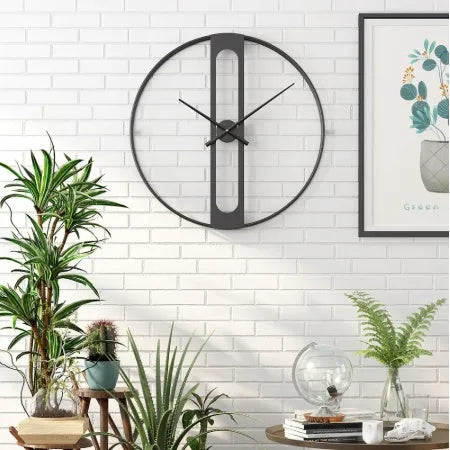 Round metal wall clock with 50cm diameter in black or gold finish on a wall