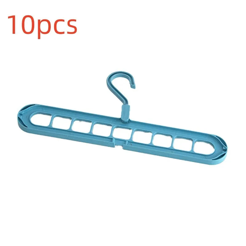 Green plastic folding clothes hanger with nine holes for organising trousers on a rack.