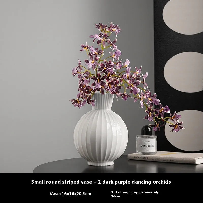 White ceramic ball vase with blue stripes on wooden table