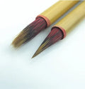 Small red writing brush with mixed sheep and wolf hair bristles on wooden handle