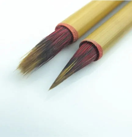 Small red writing brush with mixed sheep and wolf hair bristles on wooden handle