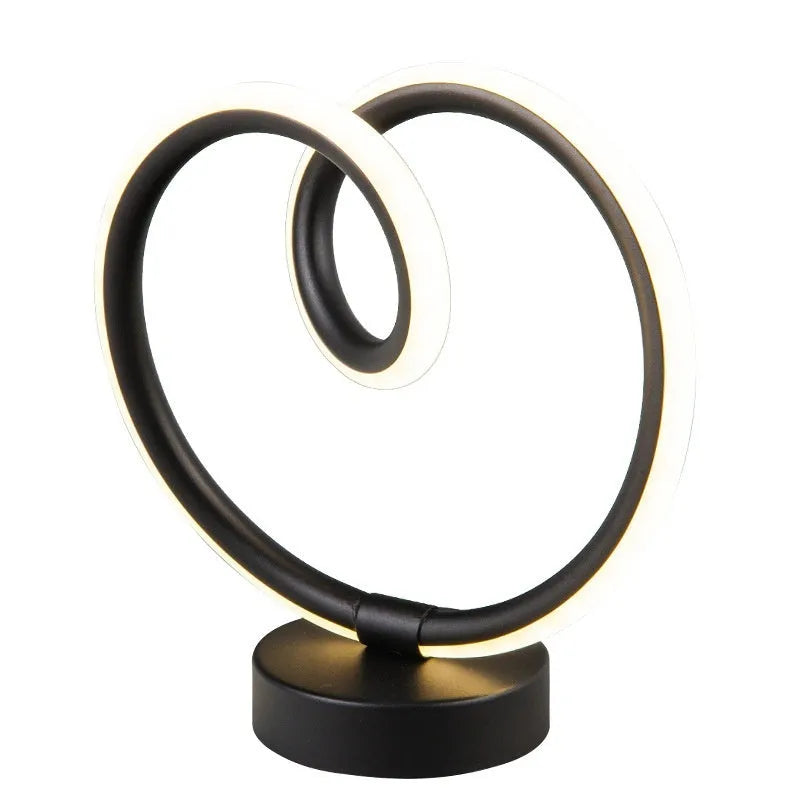 Black musical note shaped Bluetooth light with remote control on a bedside table.
