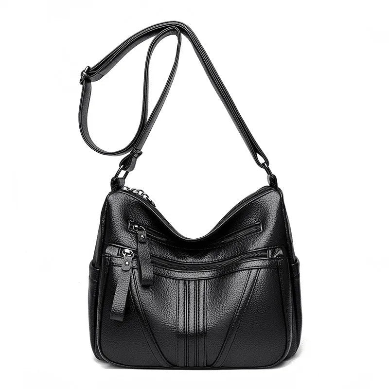 Genuine leather horizontal square messenger bag in black with contrast stitching and a front slit pocket.