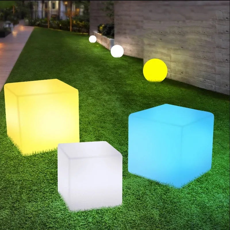 Modern white LED cube stool light outdoors, showing flat top and clean design.