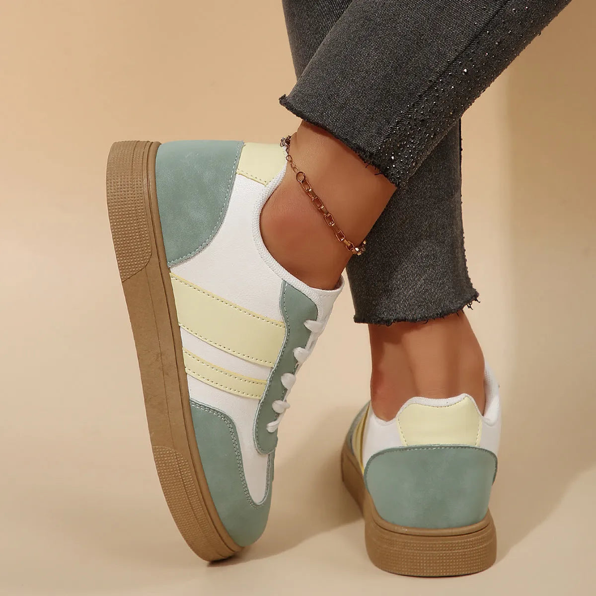 Green retro sports women's pumps with cross straps, leather stitching, round toe, and a low flat rubber sole.