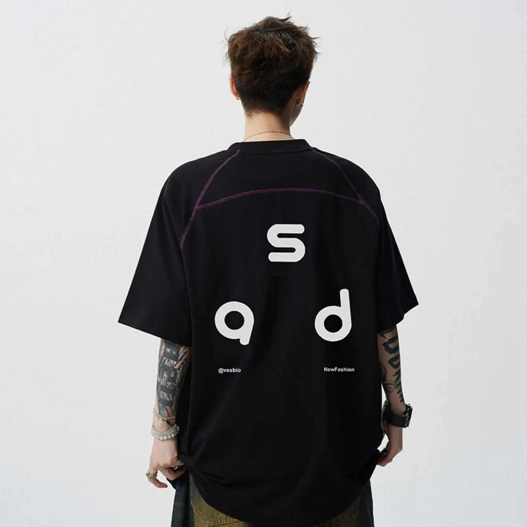 Man wearing a black loose-fit cotton t-shirt with a white letter print on the front.