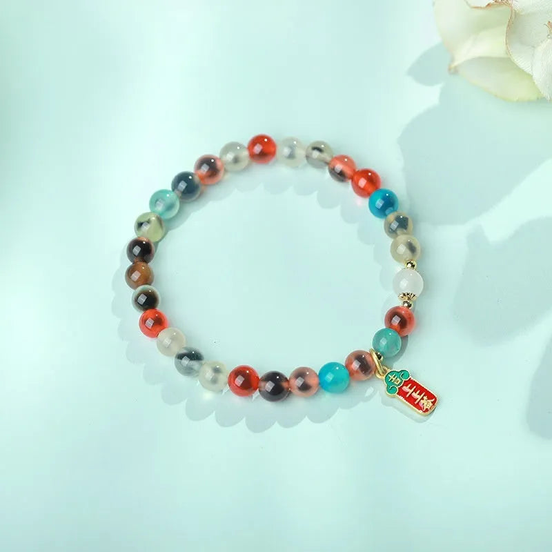 Handmade women's agate bracelet with coloured glaze copper coins in a snake chain, showing fu character or swallowing gold beast motifs.