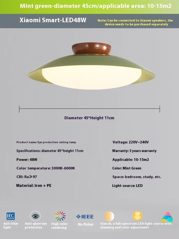 Modern minimalist cream style flying saucer ceiling lamp in mint green on a white ceiling.