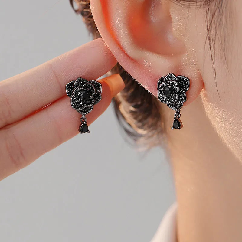 Pair of black rose zircon floral stud earrings with an 18K gold electroplated finish on copper.