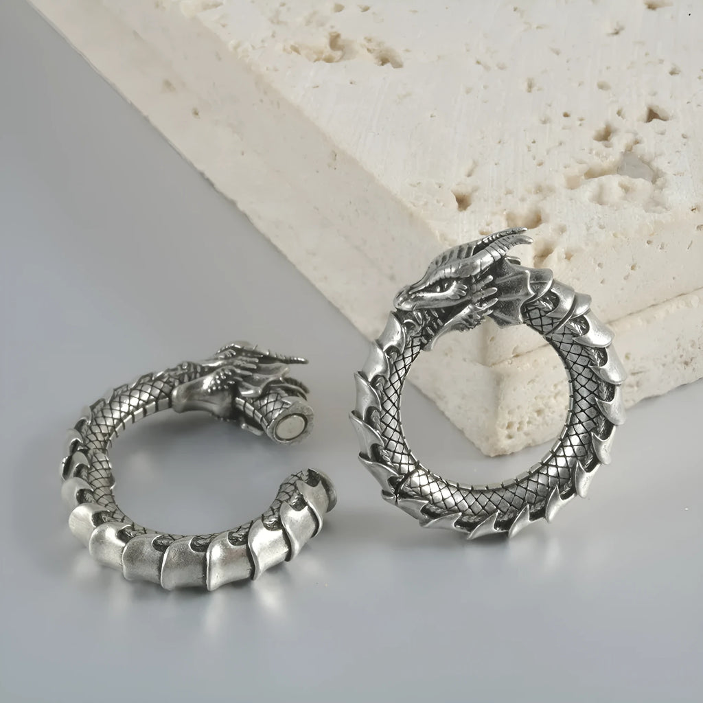 A pair of antique silver alloy earrings in a geometric dragon shape with hollow out design.