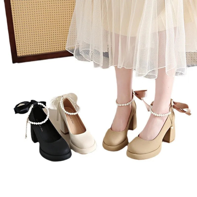 Women's beige Mary Jane shoes with a chunky block heel and an ankle-strap buckle on a round toe.
