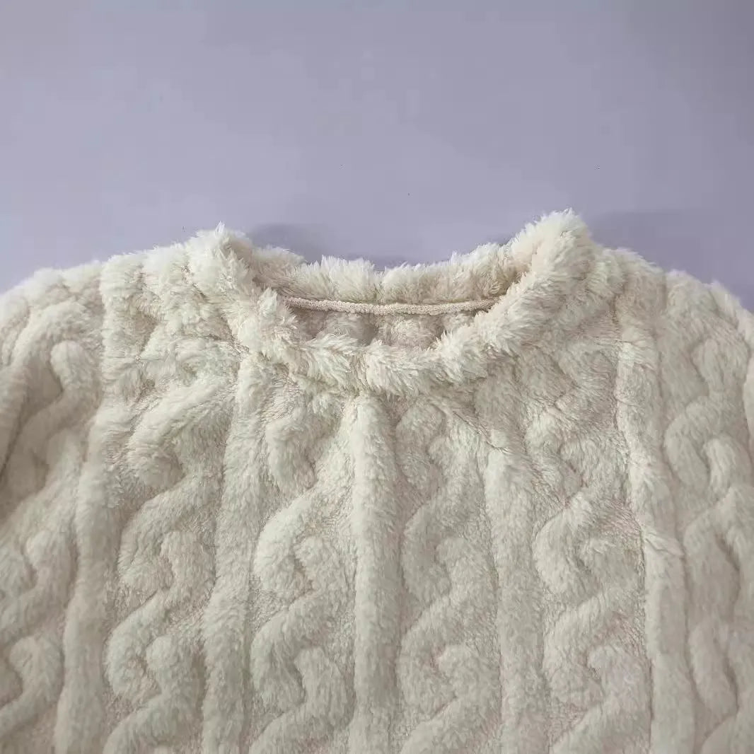 Creamy white women's long sleeve crew neck top and trouser set on a hanger.