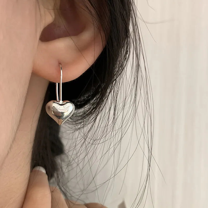 Silver-coloured heart-shaped earrings with three-dimensional design and glossy Korean style