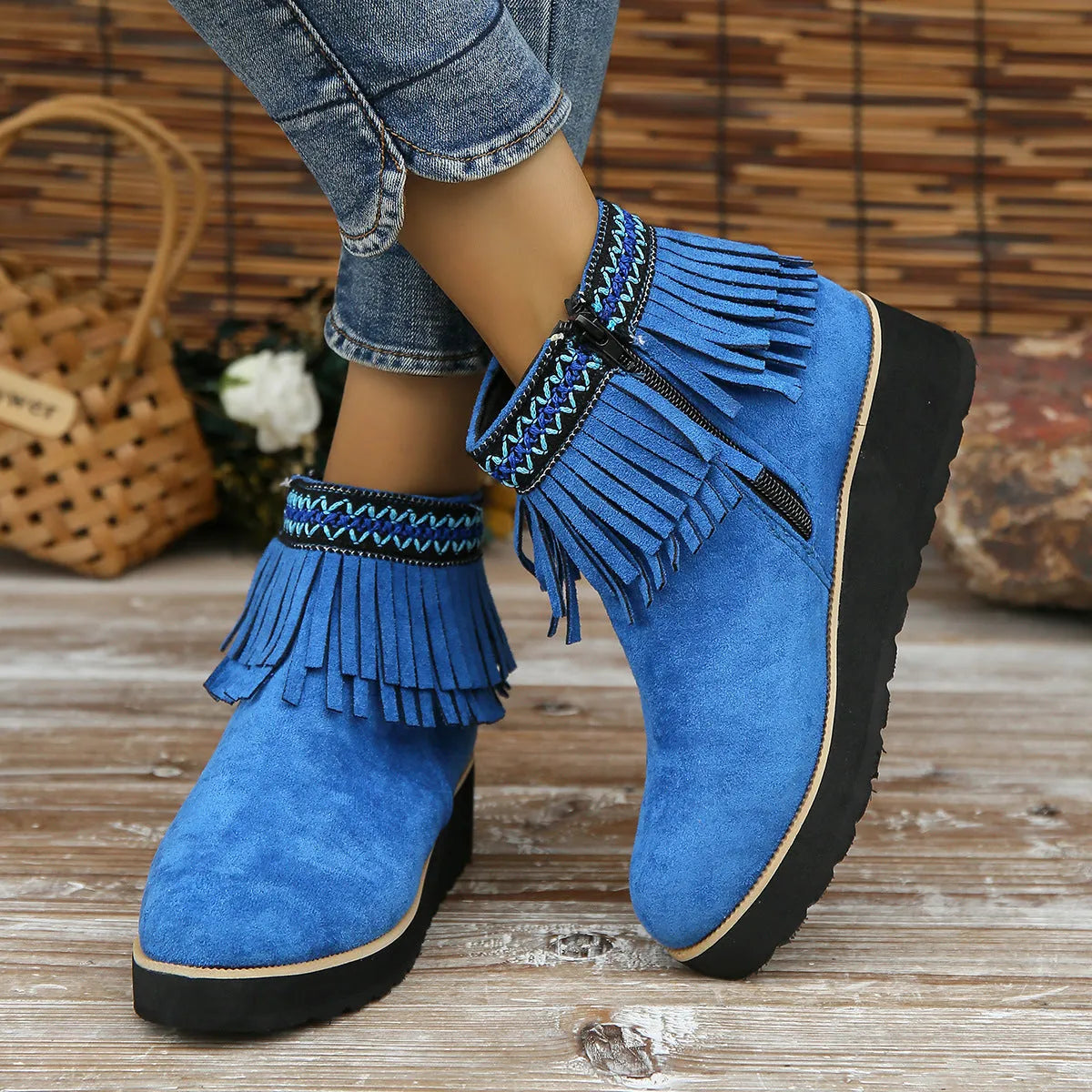 Women's suede ankle boots with a wedge heel, side zipper, tassel detail, and thick rubber sole.