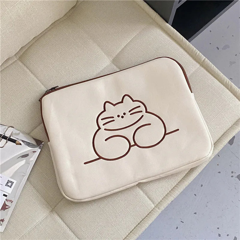Embroidered fat cat design on a navy blue nylon laptop sleeve with a black zip