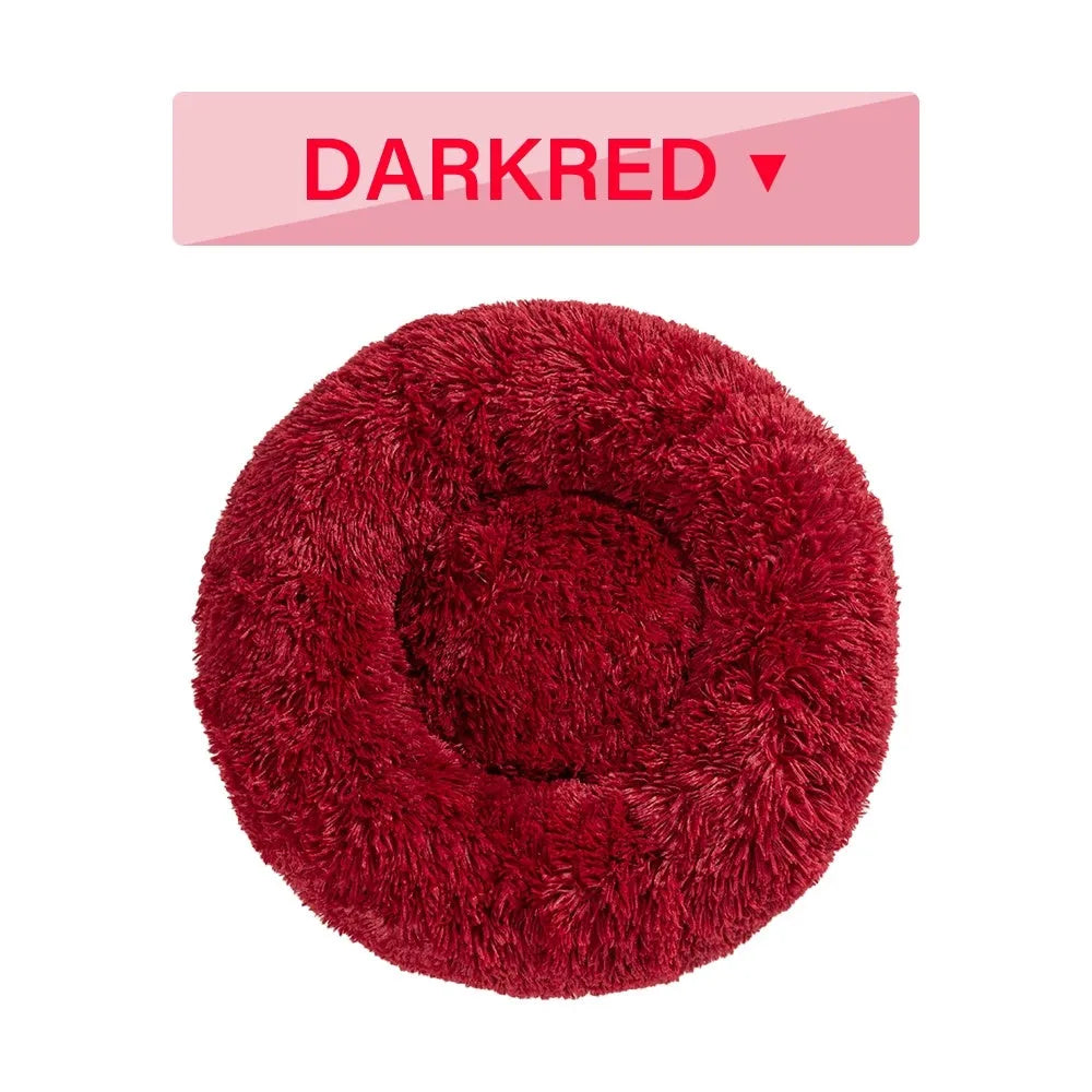 Fluffy donut-shaped dog bed in long plush material, shown in a light grey colour.