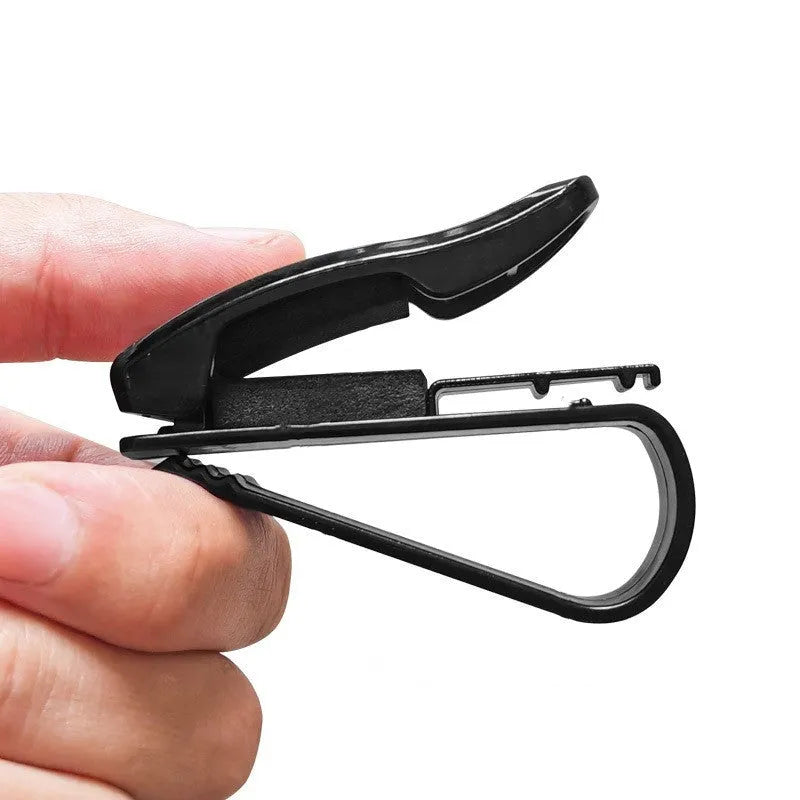 Black plastic clip for holding glasses and cards on a car sunshade