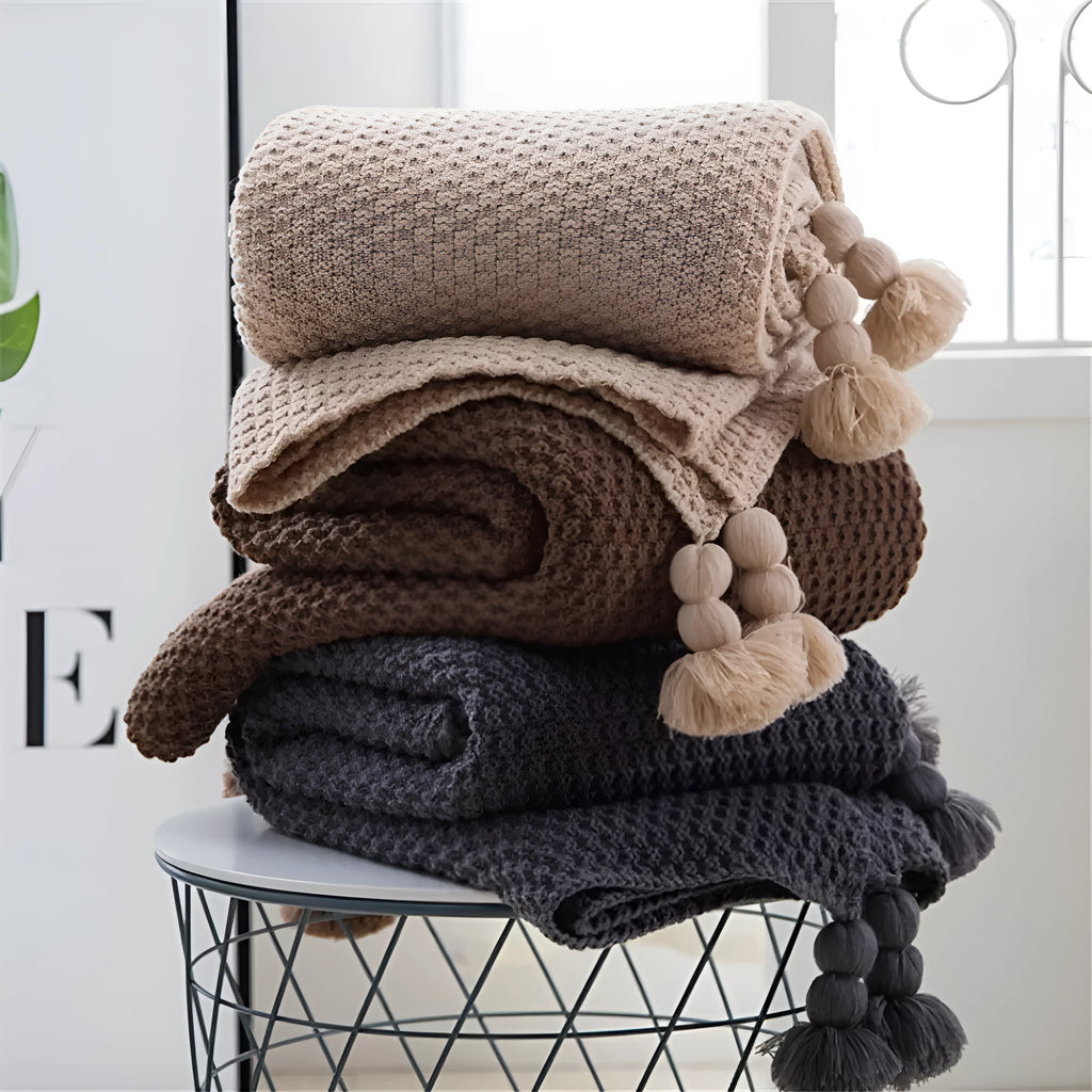 Nordic fringed knit ball acrylic blanket in beige colour on sofa