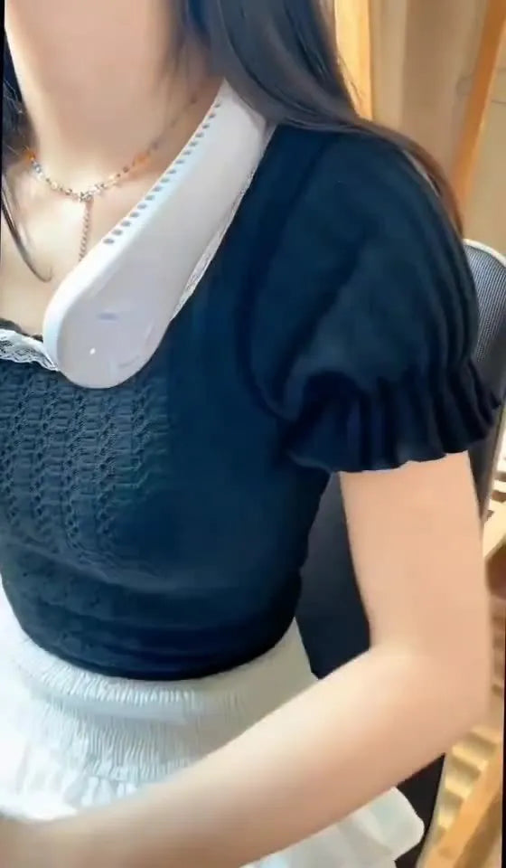 Pink portable bladeless neck fan hanging around a person's neck, showing the flexible design and air outlets.