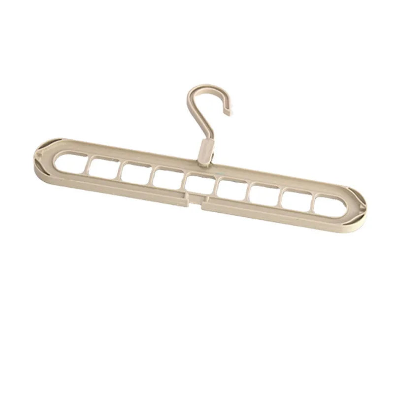 Green plastic folding clothes hanger with nine holes for organising trousers on a rack.