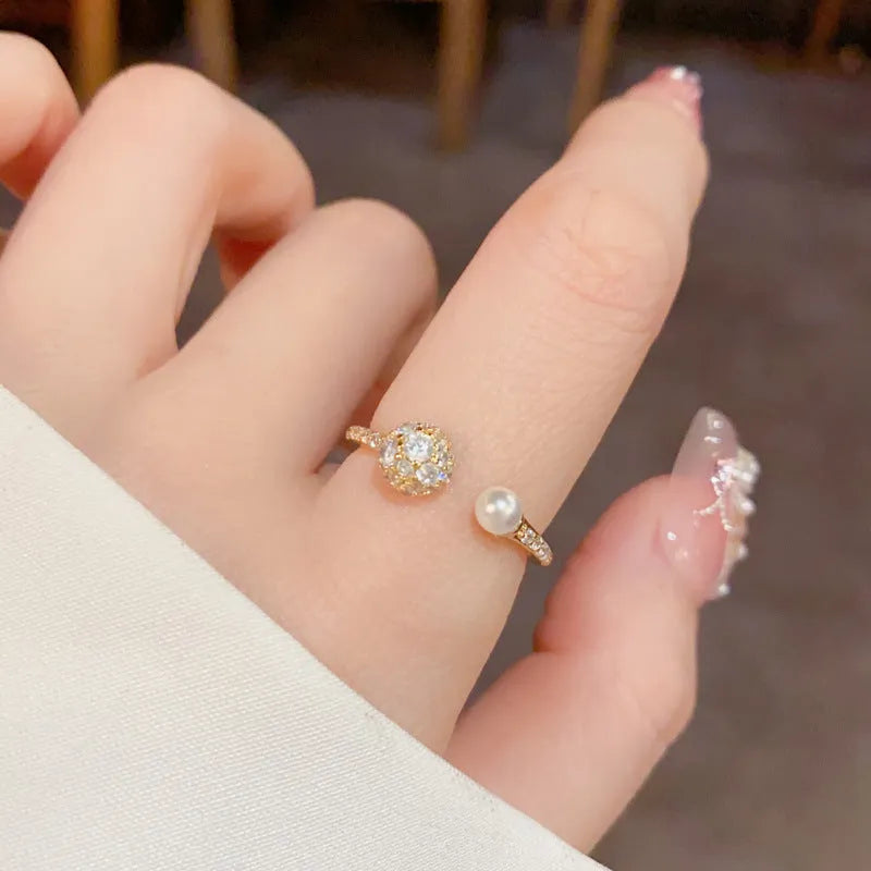 Golden open-end ring with a round zircon stone on a simple geometric band.