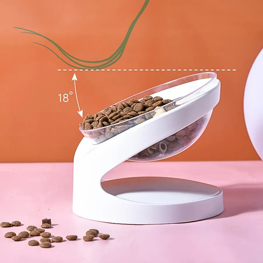 Clear plastic elevated cat food bowl with tilt design on white surface