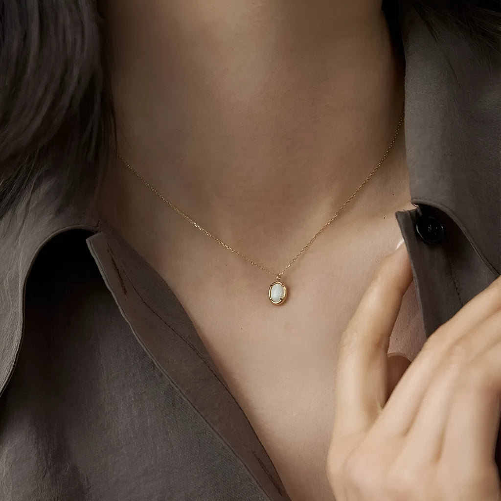 Geometric oval jelly opal pendant necklace on a chain in gold or silver tone.