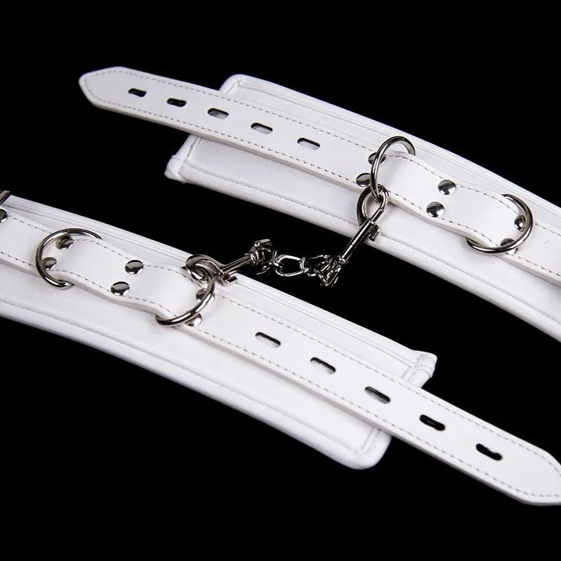 White PU sponge bondage set showing handcuffs, ankle cuffs, and a neck cuff on a neutral background.