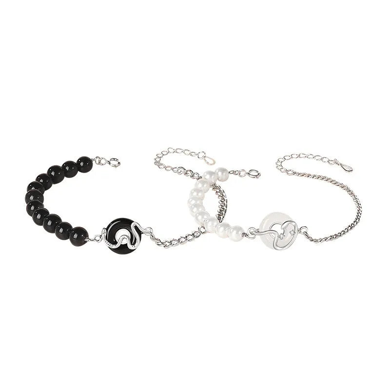 925 sterling silver bracelet with snake charm, obsidian pearl, and safe buckle closure on a wrist.