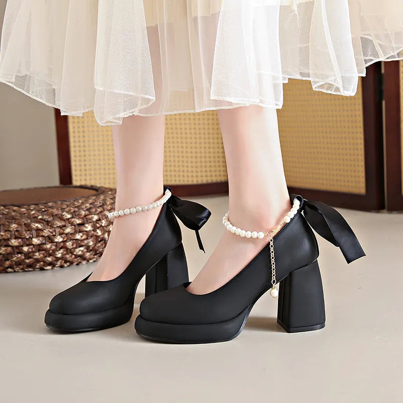 Women's beige Mary Jane shoes with a chunky block heel and an ankle-strap buckle on a round toe.