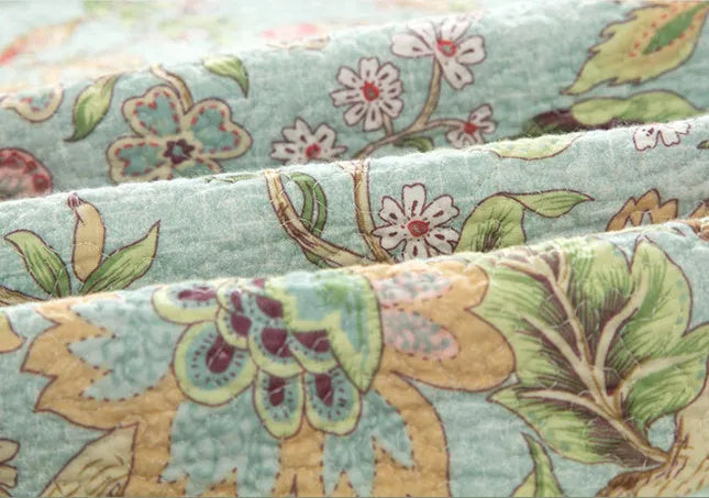 Blue American floral quilted cotton bedspread set on a bed, showing the three-piece 230x250 cm cover.
