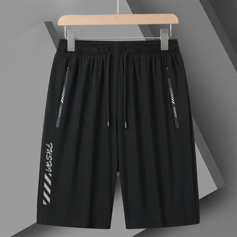 Man wearing black loose-fit quick-drying nylon sports shorts with a five-inch length.