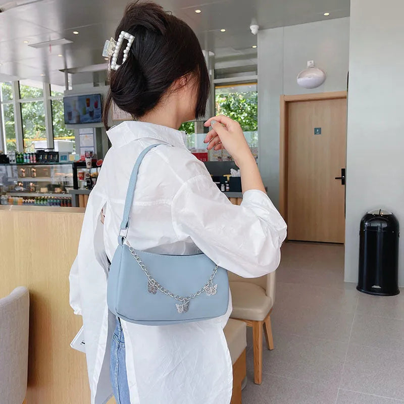 A structured square women's chain underarm bag in PU leather, shown in black, white, khaki, and light blue colour options.
