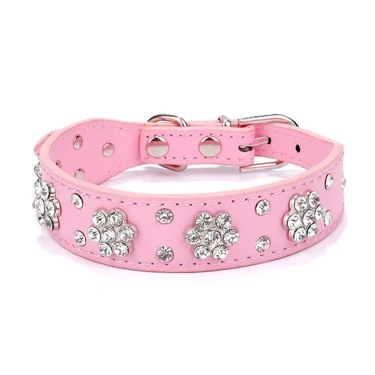 Decorative dog collar made of black PU leather with a pattern of rhinestone flowers and studs, showing the metal D-ring.
